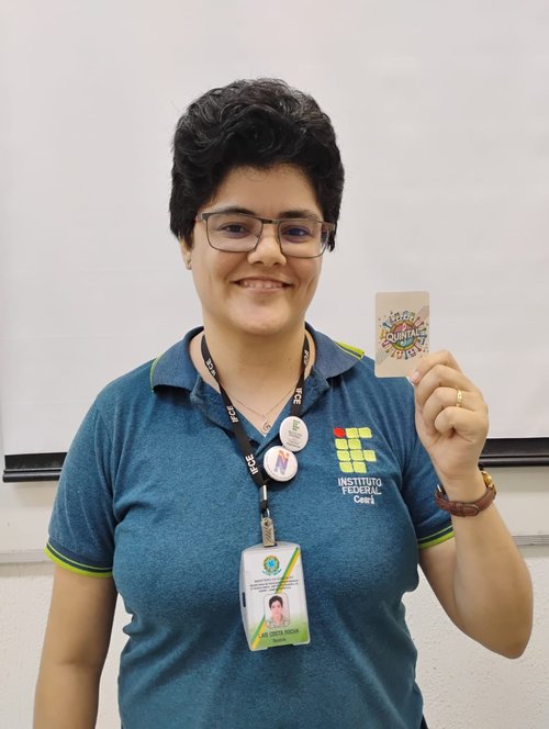 Professora Laís Costa mostrando carta do jogo Quintal