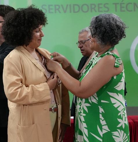 Sulamita Lino recebe o tradicional pin da pró-reitora de Extensão, Ana Uchôa